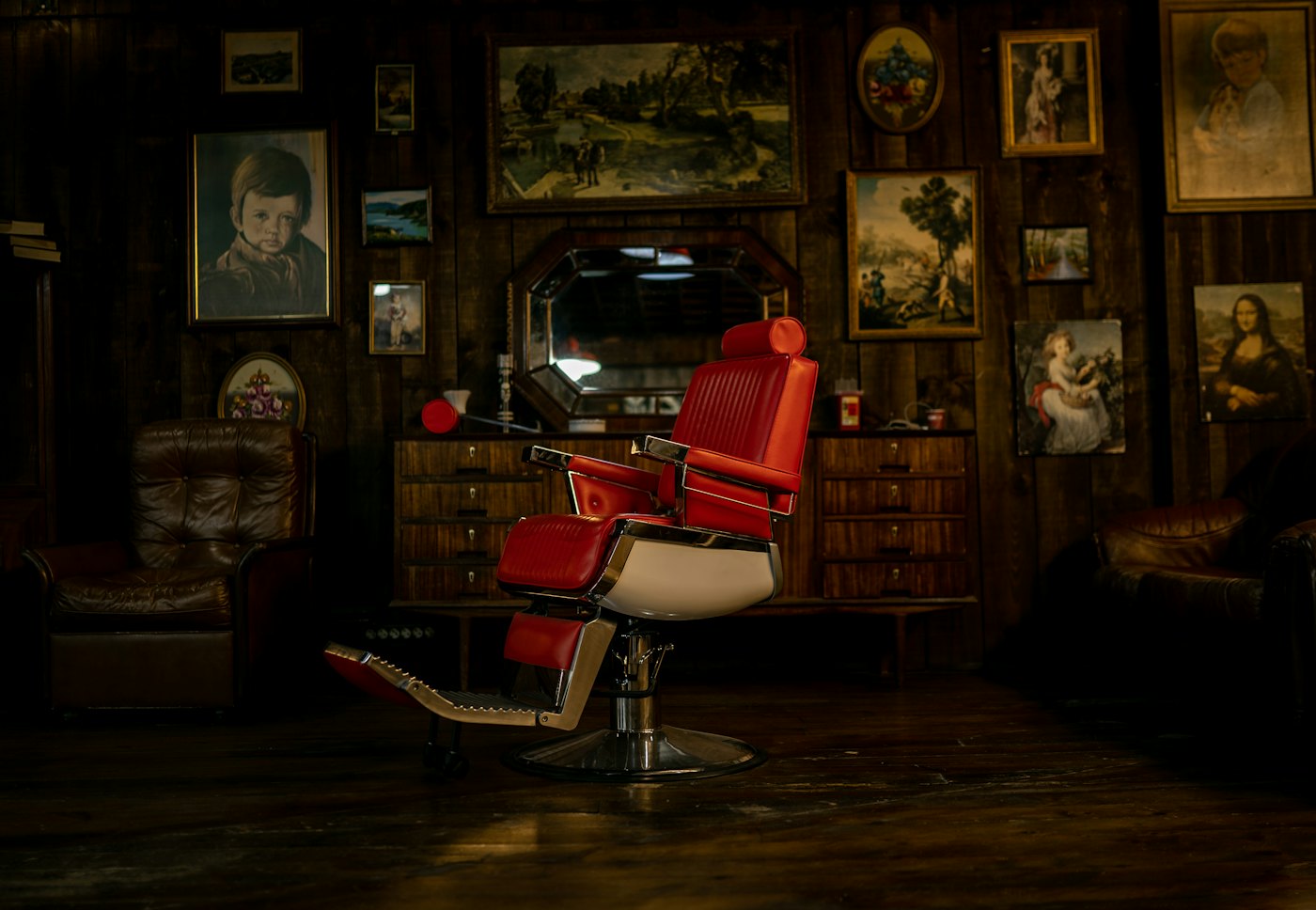 A vintage red barber chair in a wood-panelled shop