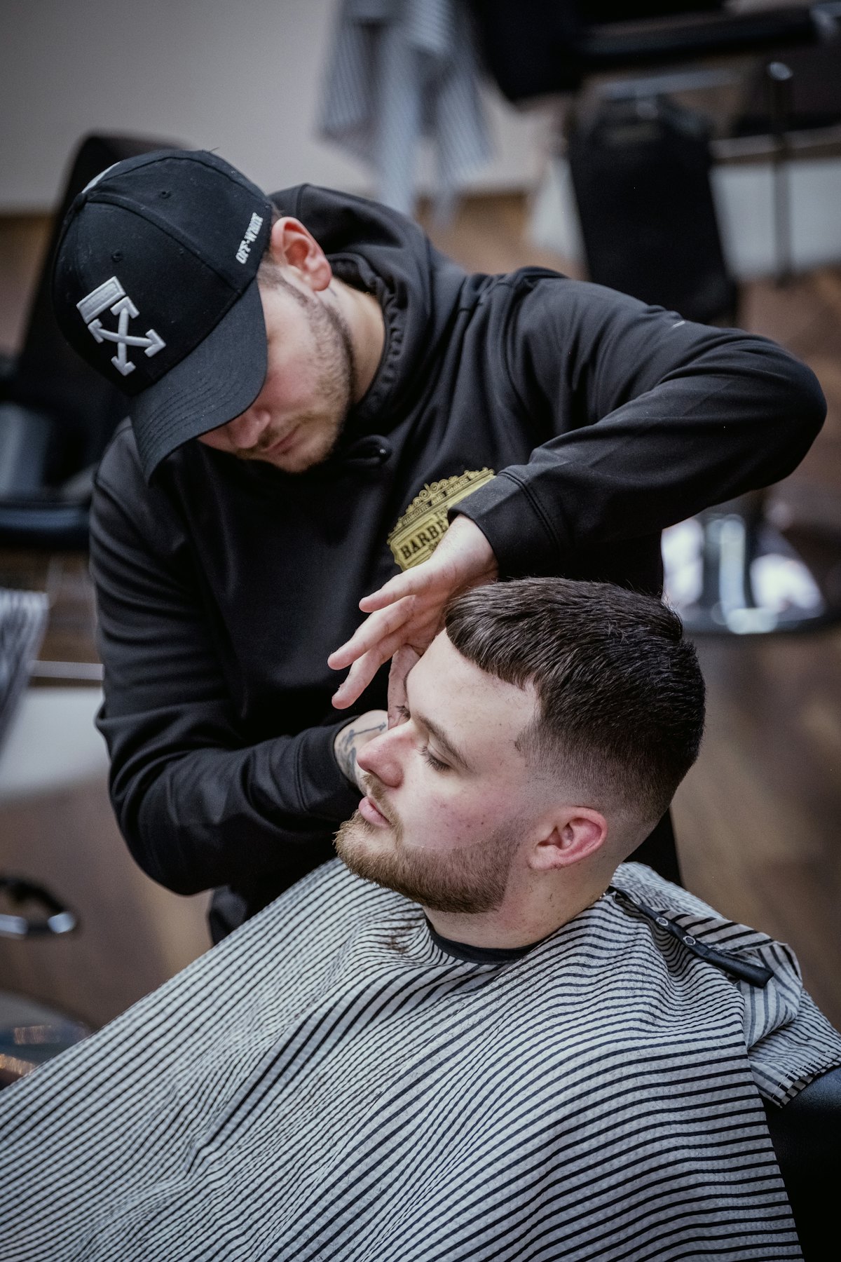 A barber finishing a short textured crop