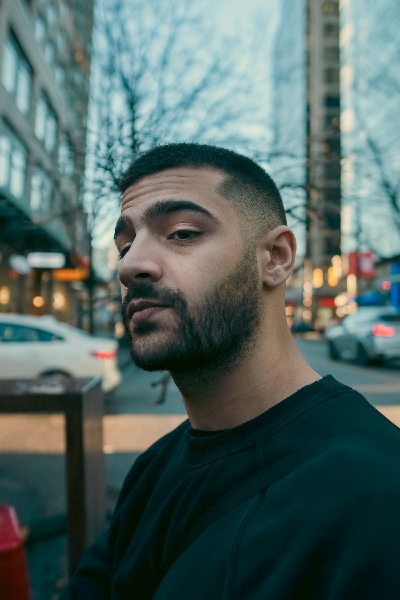 A finished skin fade with a short textured crop and neat beard