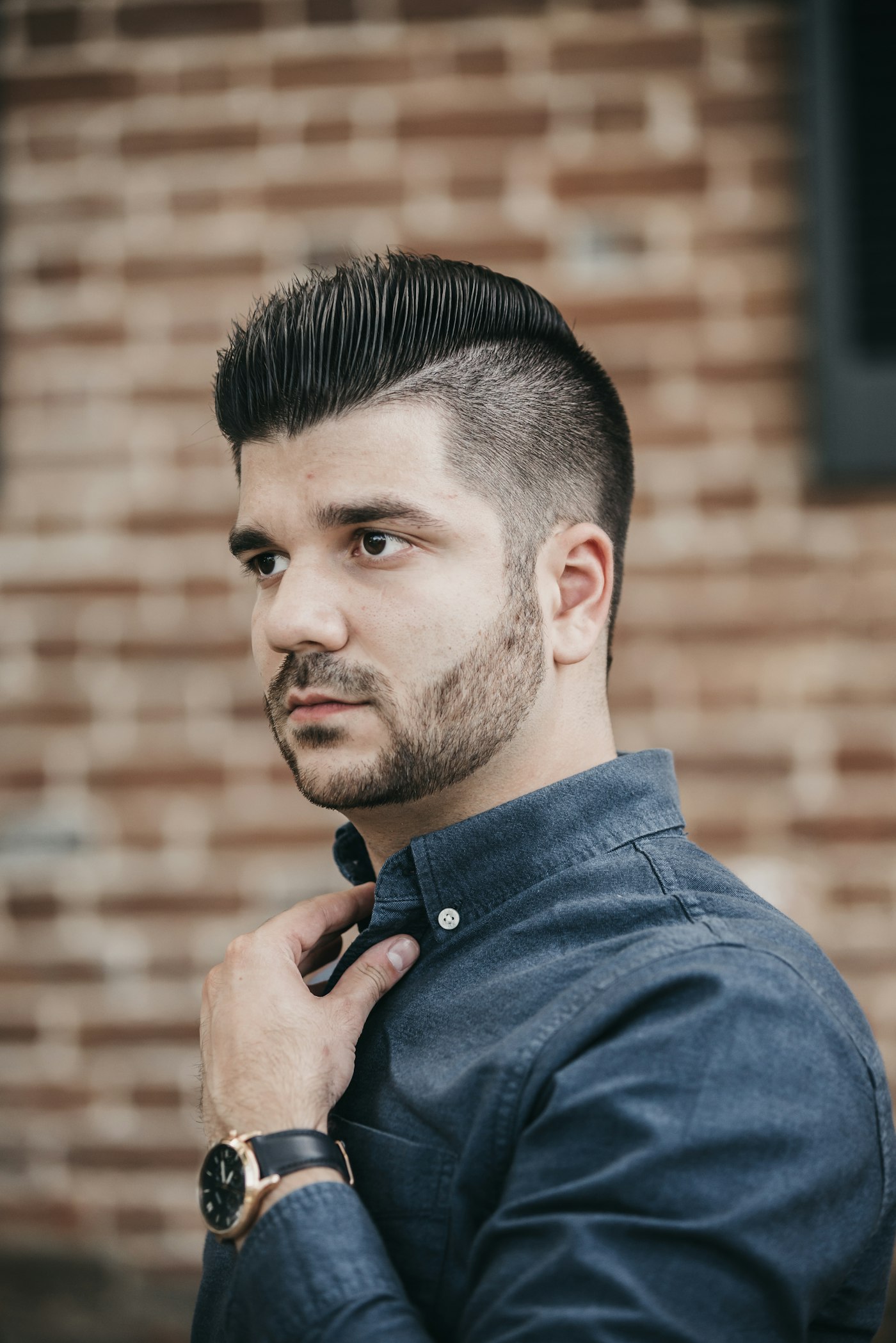 A slick pompadour with faded sides and a short beard
