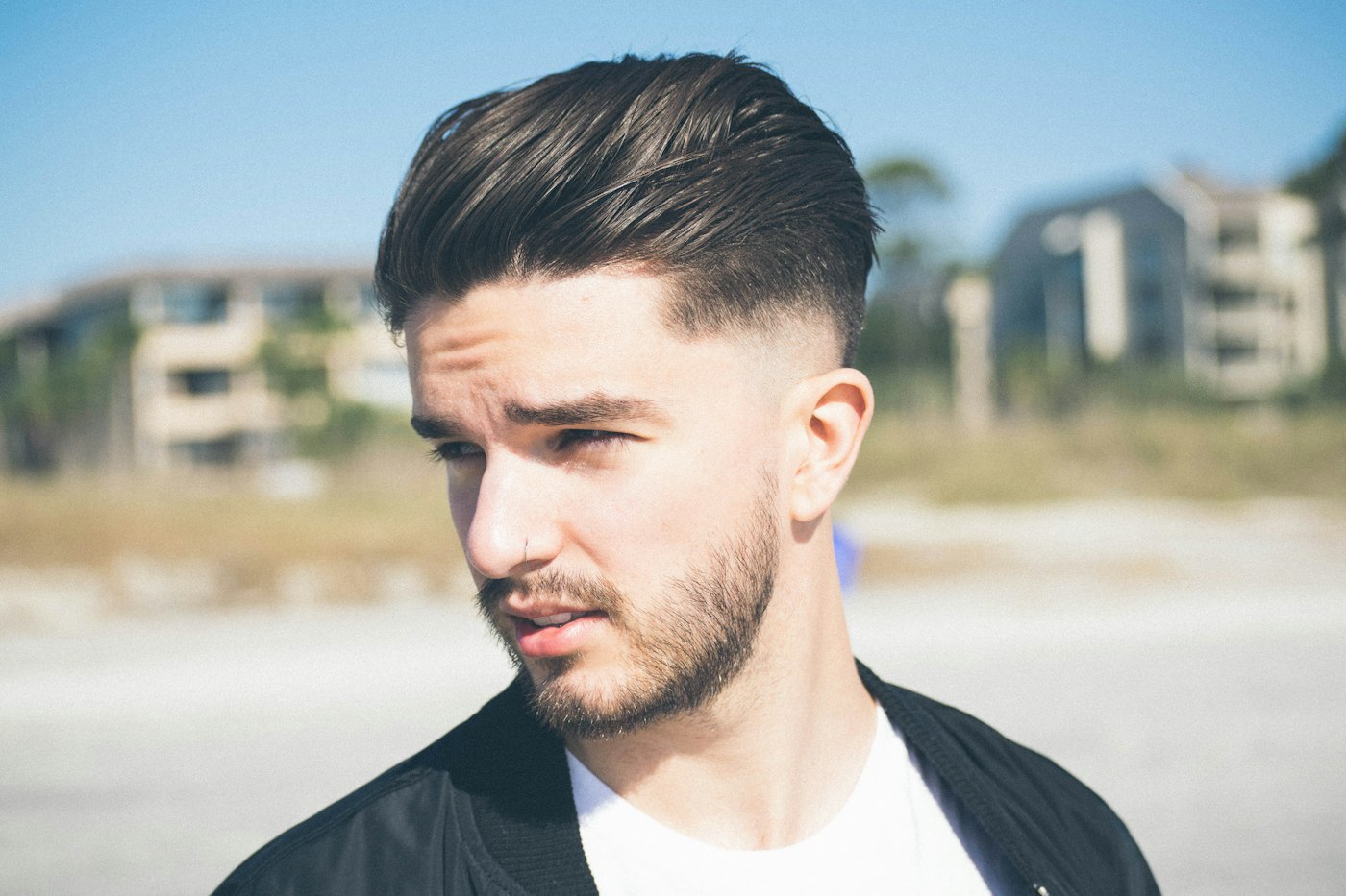 A swept-back quiff with tapered sides, outdoors