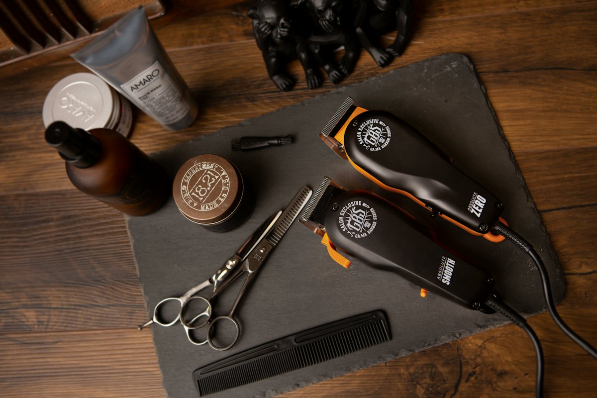 Clippers, scissors and a comb laid out on slate